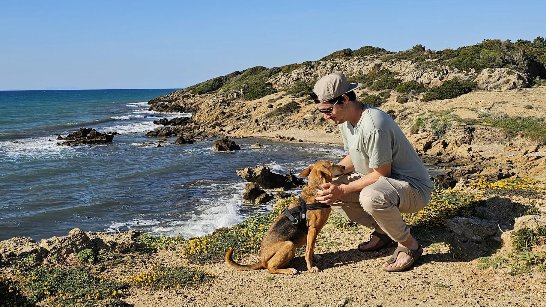 Der Gründer von hej iara streichelt Iara am Strand